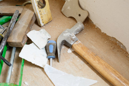 Tools for construction and repair lie on the concrete floor during repair work with a spatula, hammer, tape measure. To make repairs. Selective focusの写真素材
