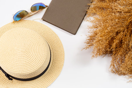 Mobile phone, notepad, hat, lifestyle, woman, relax, with dry grass, decor, flat lay, style on a white background. Travel, tourism concept. Beach accessories top view.の写真素材