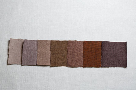 square pieces of multi-colored fabric laid out on a gray backgroundの写真素材