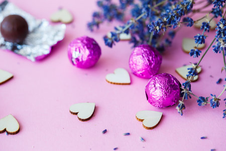 Valentine's day background. row of wooden hearts on a pink background, side view of a branch of dry lavender. Valentine's day concept. Top view, place for an inscription, advertisingの写真素材