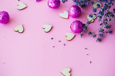 Valentine's day background. row of wooden hearts on a pink background, side view of a branch of dry lavender. Valentine's day concept. Top view, place for an inscription, advertisingの写真素材