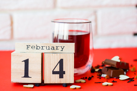 Wooden calendar with the date of February 14 on a bright red background. Romantic date. Valentine's...