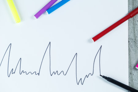 many multi-colored markers for drawing with drawings on white paperの写真素材