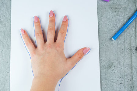 Girl draws with multi-colored felt-tip pens on white paperの写真素材