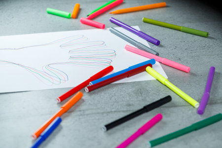 many multi-colored markers for drawing with drawings on white paperの写真素材