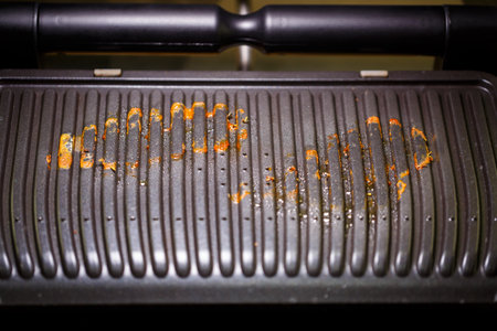 Dirty electric grill after use by the cook. Cooking at home