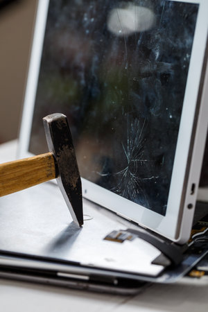 The hammer hits the broken touchscreen tablet, suggesting that it is about to replace it. Broken...