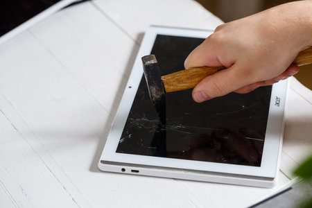 The hammer hits the broken touchscreen tablet, suggesting that it is about to replace it. Broken...