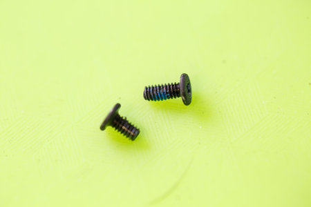 Small screws for twisting small parts for gadgets lie on a green background