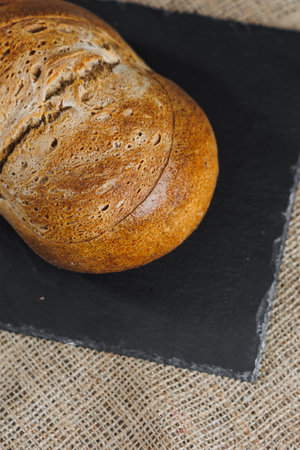 Delicious fresh rye round bread on a dark background. Crispy fresh bread. Freshly baked breadの写真素材