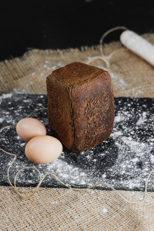 Delicious round rye bread with milk and eggs on a dark background. Crispy fresh bread.