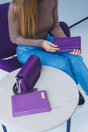 A purple leather bag in a girl's hand. Woman with luxury bag.の写真素材
