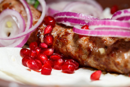 A dish cooked on the kebab grill. Georgian dishes. Garnished with onions and pomegranate seedsの写真素材