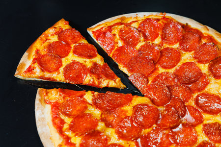 Sliced pizza with sausage, tomato sauce, mozzarella, onion and dough rim, topped with cream cheese...