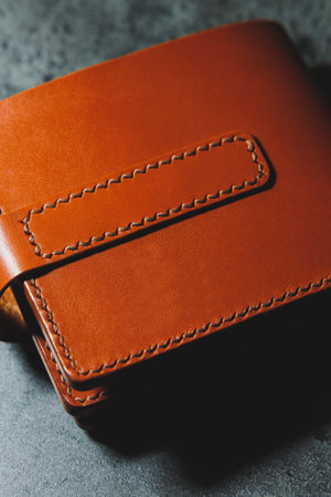 Stylish handmade brown leather men's wallet on a gray background. Product made of genuine leather.の写真素材