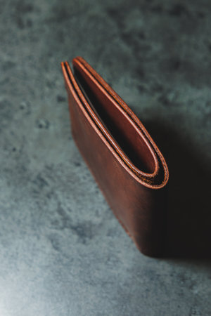 Stylish handmade brown leather men's wallet on a gray background. Product made of genuine leather.の写真素材