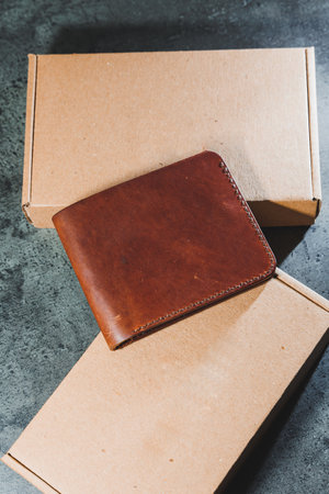 Stylish handmade brown leather wallet on a gray background. Product made of genuine leather.の写真素材