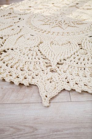 Handmade carpet knitted from natural threads, flooring, natural cotton. Beige handmade carpet. Knitted decorative itemの写真素材