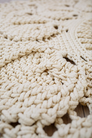 Handmade carpet knitted from natural threads, flooring, natural cotton. Beige handmade carpet. Knitted decorative itemの写真素材
