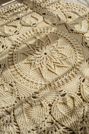 Homemade knitted carpet made of thick threads, made by hand: a handmade rug made of beige threads...