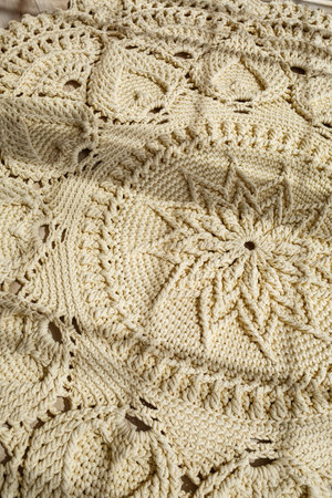 Homemade knitted carpet made of thick threads, made by hand: a handmade rug made of beige threads...