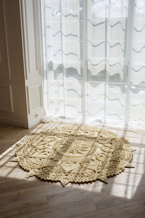Handmade carpet knitted from natural threads, flooring, natural cotton. Beige handmade carpet. Interior solution for a house or apartmentの写真素材