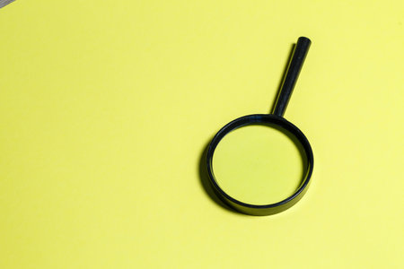 magnifying glass in a black frame on a yellow backgroundの写真素材