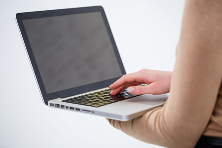 Photo of a charming woman holding a laptop and typing on businessの写真素材