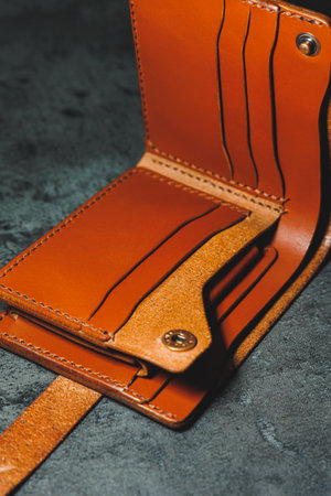 Stylish handmade brown leather men's wallet on a gray background. Product made of genuine leather.の写真素材