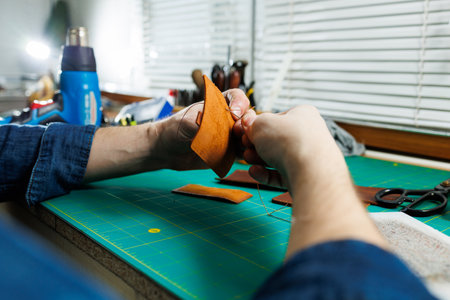Close-up of male hands working with natural leather. Handmade products made of genuine leather.