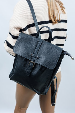 Black backpack on the shoulder of a woman, Women's backpack, gray women's backpack. Women's bag isolated on white background. The bag is isolated on a white background.の写真素材