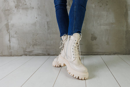 Female legs in jeans and white leather boots made of natural leather. A collection of women's spring modern shoesの写真素材