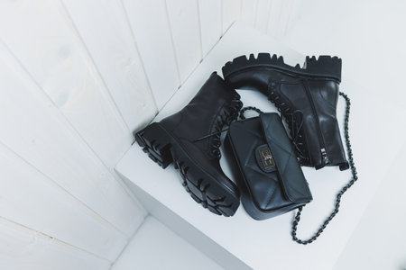 Women's leather boots on a plain background with a leather bag. New collection of women's winter...