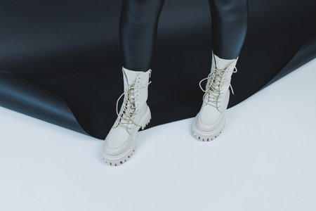 Close up of female legs in stylish fashion leather white lace up shoes. New seasonal collection of women's winter shoes.の写真素材