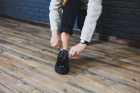 Beautiful woman with legs in fashionable clothes, stylish leather black patent leather lace-up shoes close-up. Women's image in spring styleの写真素材