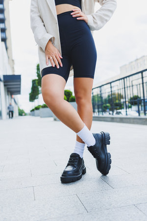 Female legs in leather shoes, white socks with and black moccasins, black shorts, fashion detailsの写真素材
