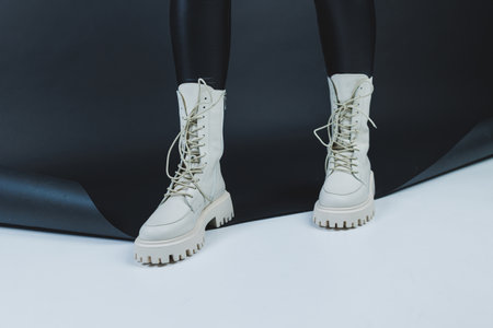 Close up of female legs in stylish fashion leather white lace up shoes. New seasonal collection of women's winter shoes.の写真素材