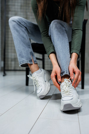 Close-up of female legs in jeans and shoes in fashionable sneakers close-up. Women's everyday fashionable shoes.の写真素材