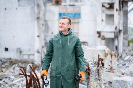 A man takes off a protective mask and he is dressed in protective clothing explores a dangerous radioactive zone.の写真素材