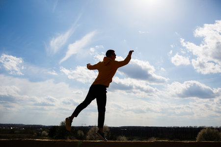 guy tourist freelancer on a background of blue sky with white clouds, bright sunny day, nature and human freedomの写真素材