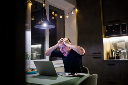 Wtf Oh my God Oh no A young amazed emotional man with a grimace looks at the devices screen he...