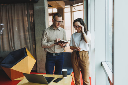 Young male and female colleagues work in a spacious office. Successful people are working on a new...