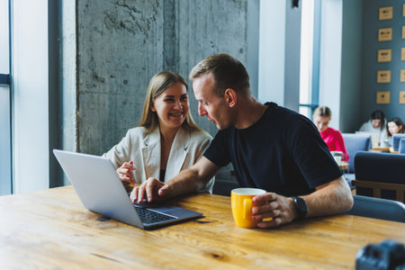 Young colleagues managers are sitting at the table and laughing. Concept of business cooperation and...
