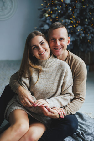 A beautiful couple embraces during a New Year's photo session. Lovers welcome the new year together. A couple in love enjoying each other on New Year's Eve. New Year and Christmas. February 14th.の写真素材