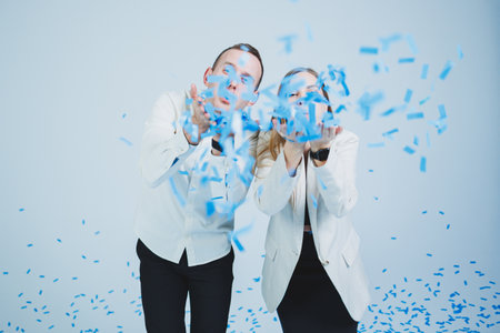 Young happy married couple hugging in blue confetti. A couple in love rejoices and has fun. Gender photo sessionの写真素材