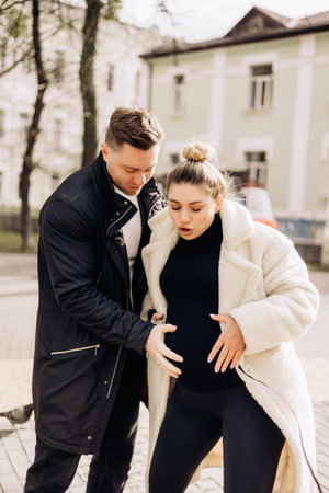 A young couple in love is walking on the street and enjoying the fresh air. Happy married couple. A stylish couple, a man and a womanの写真素材