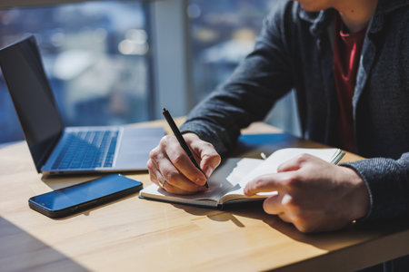 Close-up of a businessman's male hands with a notepad and a penの写真素材