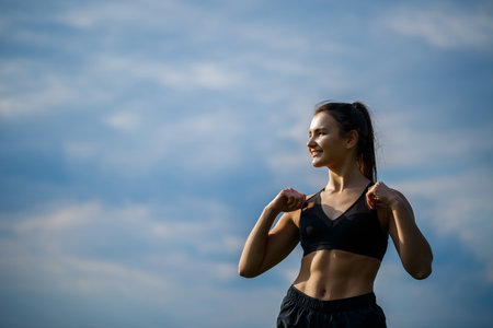 Healthy lifestyle concept. Young attractive woman in sportswear makes stretching her hand before...