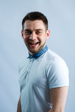 Portrait of a man in a white polo on a white background. Male image for every day. Stylish guyの写真素材