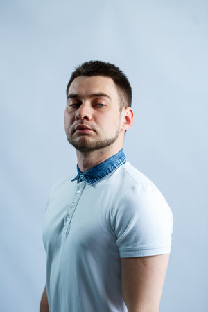 Portrait of a man in a white polo on a white background. Male image for every day. Stylish guyの写真素材
